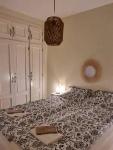 a bedroom with a large bed with a black and white blanket at Appartement calme à 200 m de la mer avec ascenseur in Alcalá