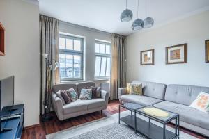 a living room with a couch and a tv at Lapwing Apartments Monte Cassino in Sopot