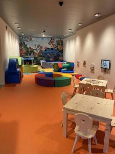 a childrens play room with tables and play equipment at Alpen-Suite mit Spa & Bergblick in Churwalden