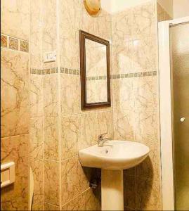 W łazience znajduje się umywalka i lustro. w obiekcie “ La Ginestra ” in Maremma w mieście Ischia di Castro
