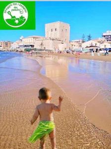 - un jeune enfant qui se promène sur la plage dans l'établissement CASA ANGELA, à Pozzallo