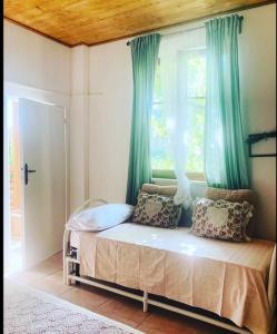 łóżko w pokoju z oknem z niebieskimi zasłonami w obiekcie “ La Ginestra ” in Maremma w mieście Ischia di Castro