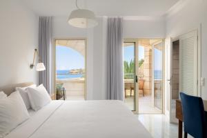 a bedroom with a bed and a view of the ocean at Macaris Suites & Spa in Rethymno Town