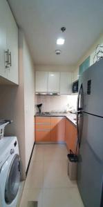 a kitchen with a washing machine and a refrigerator at Mactan Newtown Affordable Suite with FREE Pool & Beach in Mactan