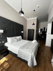 a bedroom with a large bed with a black headboard at Amani Apartments - Glasgow City Centre in Glasgow