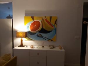 einen Tisch mit einer Lampe und ein Gemälde an der Wand in der Unterkunft Casa de la Sierra in Arroyo de la Plata