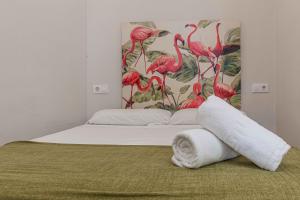 - une chambre dotée d'un lit avec des flamants roses sur le mur dans l'établissement Apartamentos Recaredo 7, Áticos con terraza, à Séville