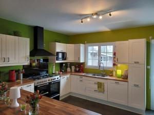 uma cozinha com armários brancos e um forno com placa de fogão em La presle em Malandry