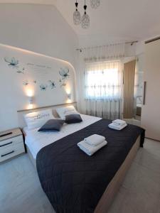 a bedroom with a large bed with two towels on it at Apartments Ostojic in Krk