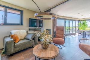 a living room with a couch and a table at Natuurvilla 18 Waswaal in De Waal