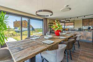 Natuurvilla 18 Waswaal في De Waal: غرفة طعام مع طاولة وكراسي خشبية كبيرة