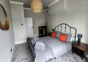 a bedroom with a large bed with orange pillows at Contemporary beach apartment in Brighton & Hove