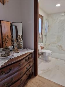 y baño con tocador de madera y espejo. en Turisme Rural Mas Vilà, en La Bisbal