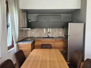 a kitchen with a wooden table and a refrigerator at Vacation House in Draç