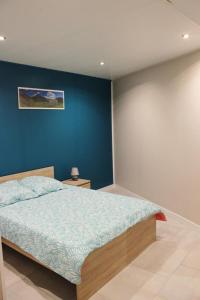 1 dormitorio con 1 cama con pared azul en La croix majot, 