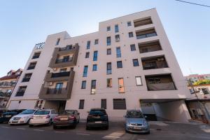 een hoog gebouw met auto's geparkeerd voor het bij Eva in Boekarest