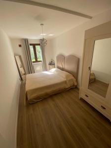 une chambre avec un lit et un grand miroir dans l'établissement Locazione turistica La Saggina, à Montevettolini