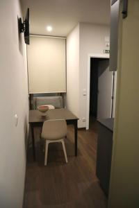 uma pequena cozinha com uma mesa e uma cadeira num quarto em CASA COELHO GUESTHOUSE em Coimbra