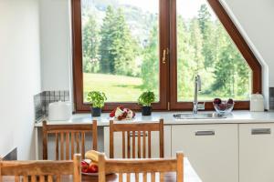 cocina con ventana y mesa con sillas en udanypobyt Apartament Koliba, en Kościelisko