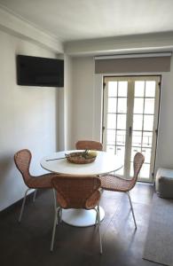 uma sala de jantar com uma mesa branca e cadeiras em CASA COELHO GUESTHOUSE em Coimbra