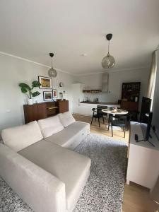 a living room with a white couch and a table at Albatross_resort_alejaa in Ķesterciems