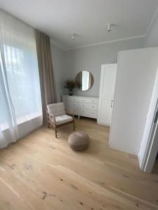 ein Wohnzimmer mit einem Stuhl und einem Spiegel in der Unterkunft Albatross_resort_alejaa in Ķesterciems
