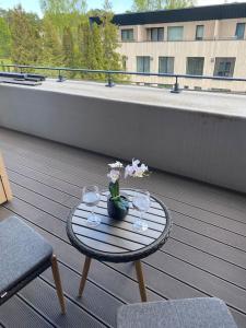 einen Tisch mit Gläsern und Blumen auf dem Balkon in der Unterkunft Albatross_resort_alejaa in Ķesterciems