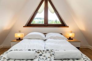 a bedroom with a bed with two pillows and a window at udanypobyt Apartament Koliba in Kościelisko