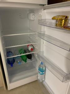 an empty refrigerator with a bottle of water in it at Dolores House PREMIUM in Ushuaia