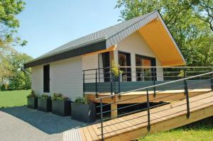 a tiny house with a porch and a deck at Le chalet in Bazeilles