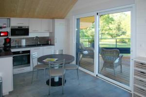 a kitchen with a table and chairs and a balcony at Le chalet in Bazeilles