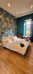 ein Schlafzimmer mit einem großen weißen Bett in einem Zimmer in der Unterkunft La Vielle Forge Périgord Vert - piscine et rivière in Saint-Paul-la-Roche