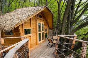 una grande cabina in legno con tetto di paglia di TREEHOUSE POD LESOM a Muráň