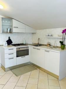 a white kitchen with a sink and a stove at Appartamento Perla Marina in Milano Marittima