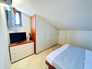a bedroom with a bed and a flat screen tv at Appartamento Perla Marina in Milano Marittima