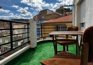 Elle comprend un balcon doté d'un sol vert, d'une table et de chaises. dans l'établissement Atico Alma, à Jalance