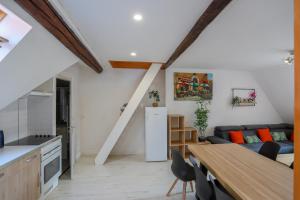 uma cozinha e sala de estar com um sofá e uma mesa em Le St-François charmant duplex 3 étoiles en Vieille Ville em Annecy