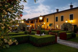 a courtyard with hedges and a building with lights at Hotel Airone in Piadena