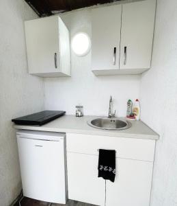a kitchen with a sink and white cabinets at BLACK SEA HOUSE in Vama Veche +18 photos