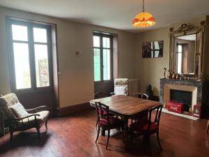 a dining room with a table and chairs and a fireplace at The Little Robin in Chevanceaux