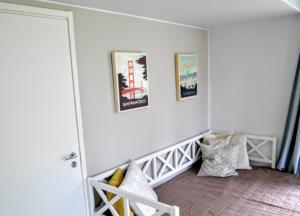 una habitación con una pared blanca con cuadros. en Cozy 4 person guesthouse on quiet residential area en Oulu