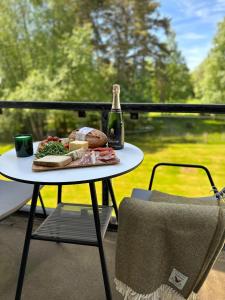 a table with a plate of food and a bottle of beer at Gleneagles Holiday Home Rental in Auchterarder
