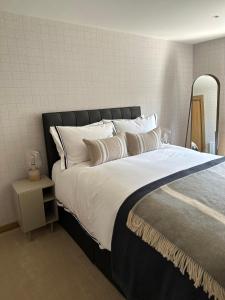 1 dormitorio con 1 cama grande con sábanas y almohadas blancas en Gleneagles Holiday Home Rental en Auchterarder