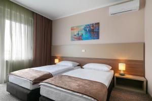 a hotel room with two beds and a window at River Inn in Stari Banovci