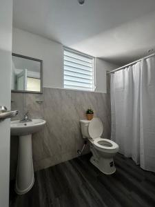 a bathroom with a toilet and a sink at Janer House at San Juan in San Juan