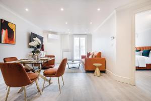 un salon avec une table et des chaises ainsi qu'une chambre dans l'établissement Marble Arch Suite 6-Hosted by Sweetstay, à Londres