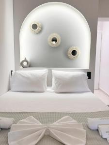 1 dormitorio con cama blanca con arco en Mora Houses, en Mandrakia