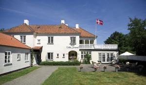 una gran casa blanca con una bandera canadiense en ella en Villa Strand, en Hornbæk