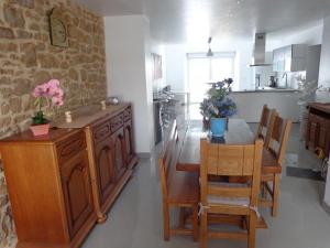 eine Küche und ein Esszimmer mit einem Tisch und Stühlen in der Unterkunft Petites fleurs des champs in Puilly-et-Charbeaux