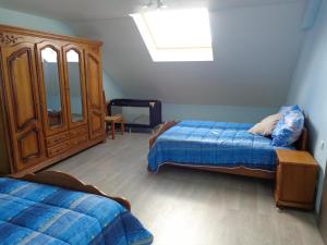 1 Schlafzimmer mit 2 Betten und einem Holzschrank in der Unterkunft Petites fleurs des champs in Puilly-et-Charbeaux